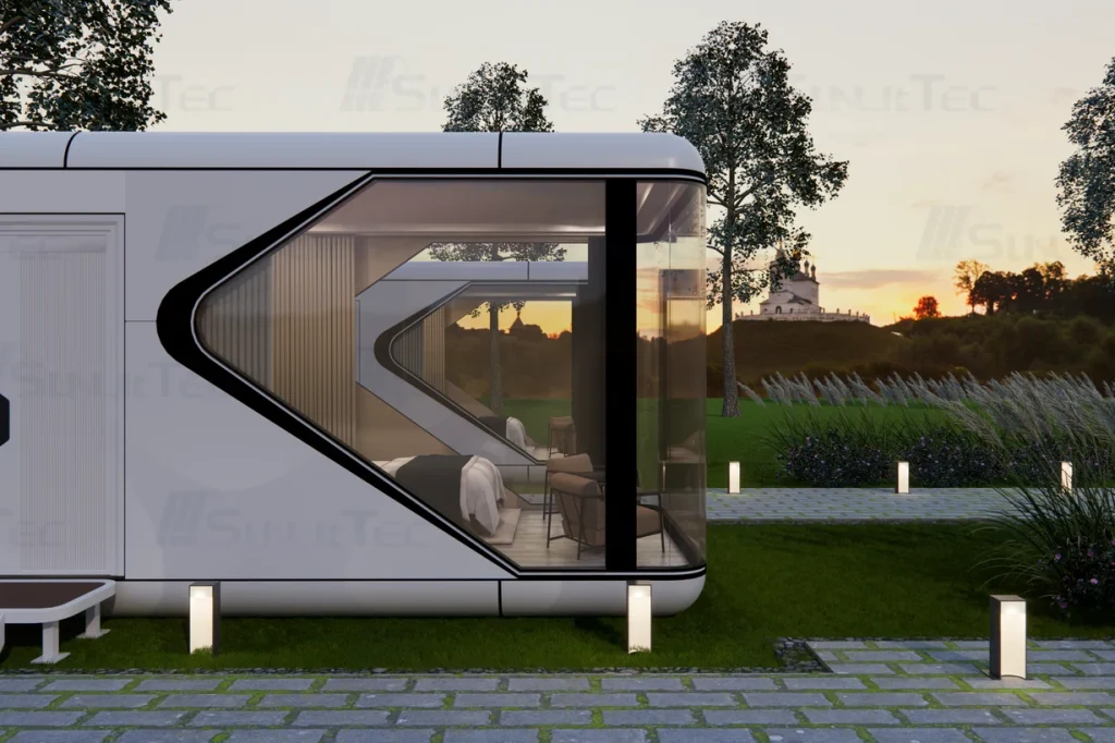 Home13sunlit-tec Rendering of a white capsule cabin with corner glazing beside a garden path